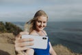 Blonde woman taking photos with her phone Royalty Free Stock Photo