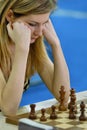 Blonde woman thinking during chess game