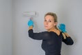 Blonde woman turning around and looking to camera while painting her new apartment Royalty Free Stock Photo