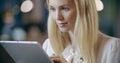 Blonde woman using tablet portrait.Corporate business team work office meeting.Caucasian businessman and businesswoman