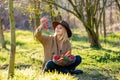 Blonde woman with vegetables in basket in blooming garden