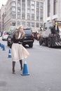 A blonde woman waiting to cross the street at Lincoln Center