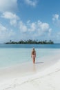 Blonde woman walking along an idyllic tropical beach