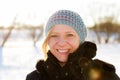 Blonde woman walking outdoors in a snowy winter landscape scene. Christmas time and winter wear concept Royalty Free Stock Photo