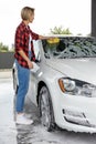 Blonde woman washing the windscreen of the car