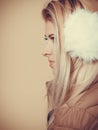 Blonde woman in winter earmuffs and jacket