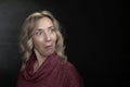 A blonde woman 35-40 years old with an emotion of strong surprise on her face on a dark background, a place for text. Royalty Free Stock Photo