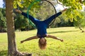 Blonde woman and young gymnast acrobat athlete performing aerial exercise on air ring outdoors in park. Lithe woman in blue