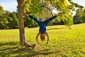 Blonde woman and young gymnast acrobat athlete performing aerial exercise on air ring outdoors in park. Lithe woman in blue