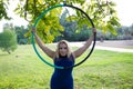 Blonde woman and young gymnast acrobat athlete performing aerial exercise on air ring outdoors in park. Lithe woman in blue