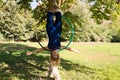 Blonde woman and young gymnast acrobat athlete performing aerial exercise on air ring outdoors in park. Lithe woman in blue