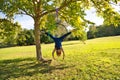 Blonde woman and young gymnast acrobat athlete performing aerial exercise on air ring outdoors in park. Lithe woman in blue