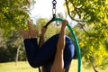 Blonde woman and young gymnast acrobat athlete performing aerial exercise on air ring outdoors in park. Lithe woman in blue