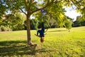 Blonde woman and young gymnast acrobat athlete performing aerial exercise on air ring outdoors in park. Lithe woman in blue