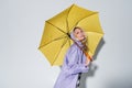 blonde woman purple rain jacket standing