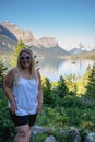 Blonde young adult woman poses for a photo at Wild Goose Island overlook in Glacier National Park Montana on a sunny day Royalty Free Stock Photo