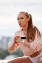 Blonde young athletic woman doing squats in a park in an urban environment. Attractive athletic woman exercising Royalty Free Stock Photo