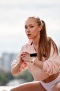 Blonde young athletic woman doing squats in a park in an urban environment. Attractive athletic woman exercising Royalty Free Stock Photo