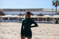 Blonde, young and beautiful woman dressed in an elegant green dress, standing on the seashore and doing different body poses. In Royalty Free Stock Photo