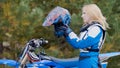 Blonde young Girl Bike wears a helmet - MX moto cross racing - rider on a dirt motorcycle