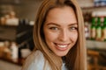 Blonde young waitress woman smiling while working at cafe