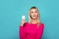 Blonde young woman a glass of milk on blue Royalty Free Stock Photo