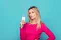 Blonde young woman a glass of milk on blue Royalty Free Stock Photo