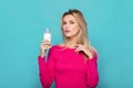 Blonde young woman a glass of milk on blue Royalty Free Stock Photo