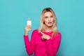 Blonde young woman a glass of milk on blue Royalty Free Stock Photo