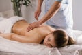 Blonde young woman model receiving relaxing massage in spa room Royalty Free Stock Photo