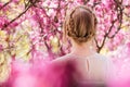Blonde young woman standing in spring blooming garden Royalty Free Stock Photo