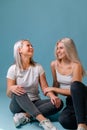 Blondehaired Mom and teenager daughter smiling on colorful backgroung. studio shoot with copy space Royalty Free Stock Photo