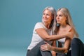 Blondehaired Mom and teenager daughter smiling on colorful backgroung. studio shoot with copy space Royalty Free Stock Photo