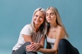 Blondehaired Mom and teenager daughter smiling on colorful backgroung. studio shoot with copy space Royalty Free Stock Photo