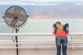 Blondie young woman posing balcony ventilator sea view.