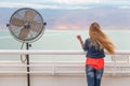 Blondie young woman wind posing balcony ventilator sea view.