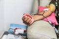Blood donor at donation with red bouncy ball holding in hand. Royalty Free Stock Photo