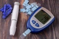 Blood glucose meter on a black wooden background