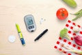 Blood glucose meter and insulin injection on the table beside to healthy food - vegetables