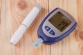 The blood glucose meter on a light wooden background