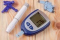 The blood glucose meter on a light wooden background