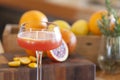 Blood orange alcohol beverage with ingredients in background