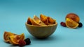 Blood orange cut in a wooden bowl in the center of the image with oranges around it, on a blue background. Concept exotic fruits Royalty Free Stock Photo