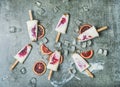 Blood orange, yogurt and granola popsicles on ice, concrete background Royalty Free Stock Photo