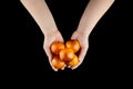 Blood oranges with red peel in hands on black background