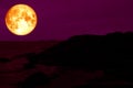 blood pink moon back silhouette rock mountain on coast