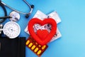 blood pressure monitor and red heart and pills on a blue background