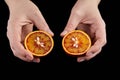 Blood or red orange fruit halves in hands on black background Royalty Free Stock Photo