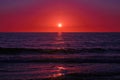 The blood red sun sets on the blue ocean. Dramatic sunset on the sea Royalty Free Stock Photo