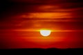 Blood red sunsetlight on the sky, sun at horizon Royalty Free Stock Photo